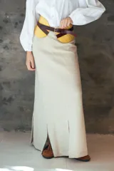 Pollera larga de tiro alto con silueta evasé, confeccionada en tejido de punto. Presenta tajos frontales y una caída fluida.