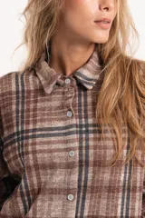 Camisa de corte oversize con estampado de cuadros en tonos marrones y beige. Presenta cuello clásico, cierre frontal con botones y mangas largas con puños simples.