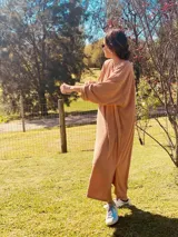 Vestido largo de lanilla color tostado, con mangas largas y corte holgado.