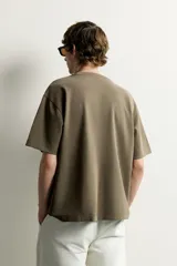 Remera de corte holgado color gris oscuro, con cuello redondo y mangas cortas. Confeccionada en tejido suave con mezcla de modal.