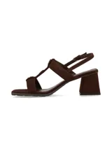 Sandalias de taco cuadrado en tono marrón chocolate, confeccionadas en gamuza. Poseen tiras cruzadas en el empeine con detalles de botones metálicos dorados decorativos, tira ajustable al talón con hebilla dorada y taco ancho estable.