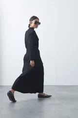 Falda midi tejida de silueta evasé, con diseño minimalista y caída fluida.