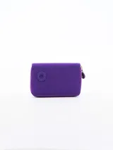 Billetera pequeña de diseño compacto en color violeta, con cierre perimetral y logo circular grabado en el frente.