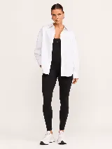 Camisa blanca de popelina oversize con cuello clásico, cierre frontal de botones y mangas largas con puños.
