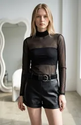 Body de tul negro con cuello alto y mangas largas, diseñado con un top interior tipo strapless a tono.