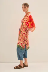 Kimono largo de viscosa con estampado multicolor de estilo étnico. Presenta bordes con detalles geométricos en contraste, mangas anchas y lazo ajustable en la cintura.