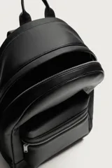 Mochila de diseño minimalista en color negro, confeccionada en material sintético con acabado grabado. Cuenta con un compartimento principal con cierre de cremallera, un bolsillo frontal con cierre y un compartimento posterior acolchado para dispositivos electrónicos. Incluye asa de mano superior y dos correas de hombro ajustables.