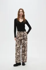 Pantalon de corte baggy con cintura media y bolsillos laterales. Presenta un estampado abstracto tipo camuflado en tonos tierra.