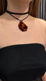 Gargantilla doble de terciopelo negro con dije de carey en forma geométrica.