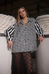 Camisa holgada estampada en blanco y negro, con cuello solapa, mangas largas con puños abotonados y cierre frontal con botones.