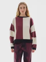 Buzo de friza con cortes verticales en color bordó y beige, calce oversized, manga larga, hombros caídos y cuello a la base.