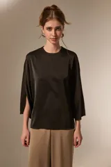Blusa de satén color negro, con cuello redondo a la base, mangas 3/4 con abertura lateral y diseño holgado.