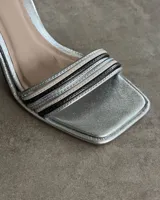 Sandalias plateadas de fiesta con tiras finas y taco geométrico.