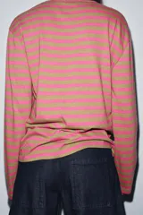 Camiseta de manga larga con cuello redondo y bajo recto, confeccionada en tejido de punto a rayas horizontales en tonos rosa fucsia y verde oliva.