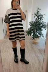 Bota alta de cuero negro con caña alta y hebillas plateadas.