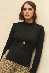 Polera negra de algodón con cuello alto y mangas largas.