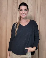 Sweater de punto con cuello en V, manga larga y diseño holgado.