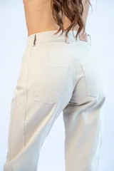 Pantalón baggy color beige con bolsillos laterales y traseros.