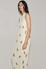 Vestido midi de viscosa color blanco con estampado abstracto marrón, diseño sin mangas, cuello redondo plisado y cierre de lazos en la espalda.
