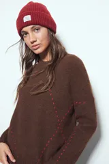 Sweater de tejido suave color marrón con diseño de líneas bordadas en color rojo. Presenta cuello redondo, manga larga y calce relajado.
