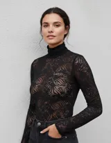 Polera de encaje negro transparente con cuello alto y mangas largas, modelo Lumiere.
