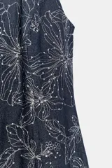 Vestido corto sin mangas de color azul marino, con escote en V y bordados florales a contraste. Presenta un diseño ajustado con corte en la cintura y falda con volante en el bajo. Cuenta con cierre de cremallera en la espalda.