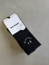 Par de medias largas negras con diseño de carita feliz y texto "BERKAMO" en blanco en la parte superior.