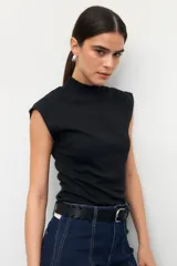 Musculosa blanca de algodón con cuello alto y sisas amplias.
