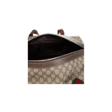 Bolsa de viaje Gucci tipo duffle bag de lona GG Supreme con monograma, asas superiores de lona con franjas verde y roja, y correa ajustable de hombro en color marrón.