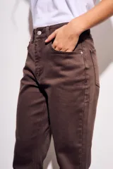 Pantalón de jean marrón de corte flare con terminación desflecada.