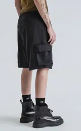 Bermuda cargo negra de corte recto, con bolsillos laterales y bolsillos cargo con solapa en los muslos. Incluye un cinturón de cinta ajustable con hebilla de plástico negra.