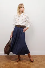 Falda larga de jean color azul oscuro con corte evasé y costuras con pespuntes a contratono. Presenta una cintura elástica para mayor comodidad.