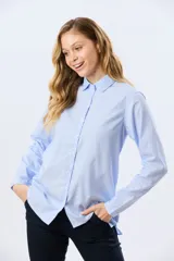 Camisa celeste rayada de corte holgado, con cuello camisero clásico y mangas largas.