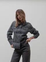 Chaqueta de denim en color gris oscuro, con corte entallado en la cintura, cierre frontal con botones metálicos y bolsillos con solapa en el pecho.