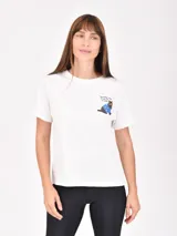 Remera blanca de corte clásico con cuello redondo y mangas cortas. Presenta un pequeño estampado en el pecho que muestra un gato con anteojos y una frase escrita.