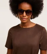 Vestido corto de gamuza color marrón, con cuello redondo, mangas cortas y cinturón con hebilla cuadrada.