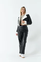 Campera corta de cuero sintético negro con interior y detalles de corderito blanco.