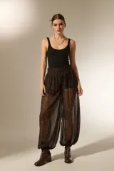 Pantalon de viscosa con diseño holgado, estampado animal print en tonos marrones y negros, cintura elástica y puños ajustados en los tobillos.