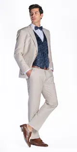 Ambo de tres piezas compuesto por saco, pantalón y chaleco. El saco y el pantalón son de color beige, mientras que el chaleco presenta un diseño estampado en tonos azul oscuro. Incluye camisa clara y moño a juego.