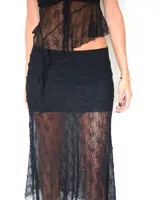 Falda midi de encaje negro con diseño asimétrico y transparencias, que presenta una base opaca corta y una capa superpuesta de encaje largo.