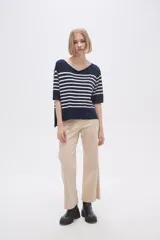 Sweater de tejido de punto con diseño a rayas horizontales en azul marino y blanco, cuello redondo amplio y mangas tres cuartos.