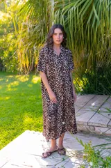 Camisola larga de muselina con estampado animal print de leopardo. Presenta cuello camisero, mangas cortas y aberturas laterales en el ruedo.