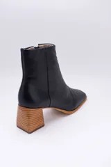 Botas plateadas de cuero con caña media, cierre lateral con cremallera, punta cuadrada y tacón geométrico de madera.