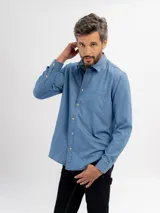 Camisa de jean de manga larga con cuello clásico, cierre frontal con botones y un bolsillo en el pecho.