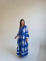 Vestido largo color azul con estampado ornamental en color blanco, escote en V con botones frontales y mangas tres cuartos con volados.