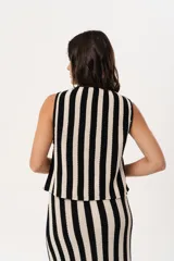 Chaleco tejido a rayas verticales en color negro y crudo, con escote en V y cierre frontal con ganchitos.
