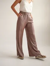 Pantalon de vestir de corte recto y tiro medio-alto, confeccionado en crepe con acabado metalizado lurex. Presenta pretina con detalle de sesgo a contratono, cierre frontal y bolsillos laterales.