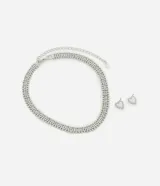 Conjunto de collar corto plateado con múltiples hileras de strass y esferas, acompañado de aros abridores con diseño de corazón calado.