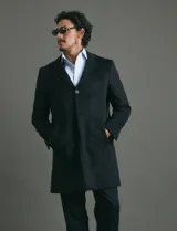Sobretodo 3/4 de paño, color gris oscuro, con cuello solapa, cierre frontal de botones, manga larga y bolsillos laterales de ribete.