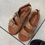 Sandalias de cuero color marrón con doble tira con hebilla ajustable, plantilla de cuero y suela de goma.